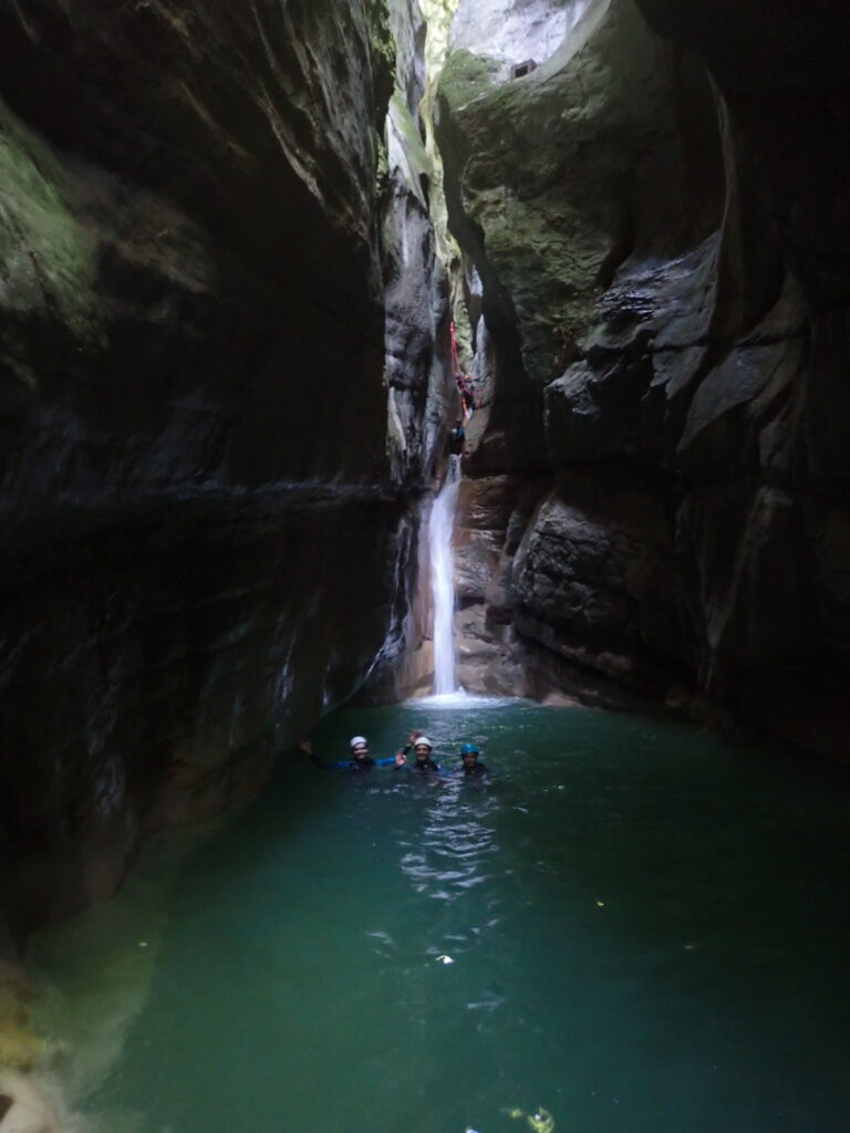 Personne dans un vasque devant une cascade dans un étroiture