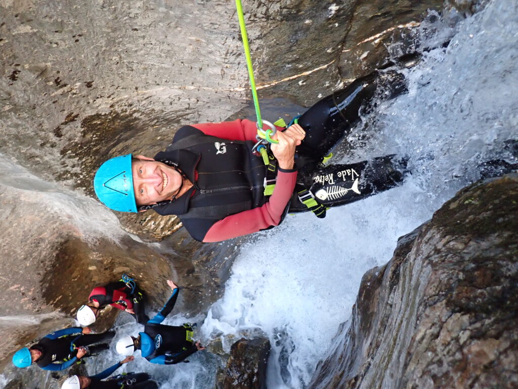 personne qui descend une petite cascade en rappel