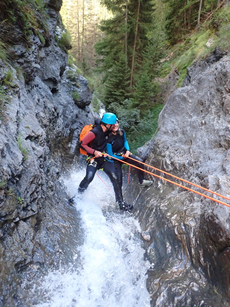 2 personnes descendent un cascade en rappel